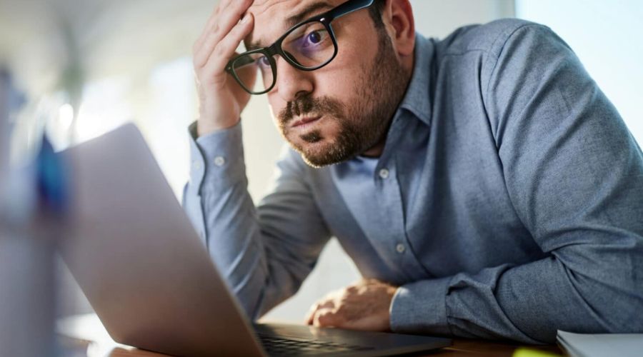 anxious man looking at laptop